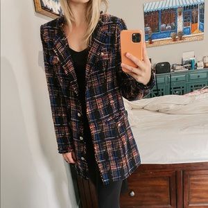 Black jacket with multicolored plaid pattern (red, orange, light pink, and blue)